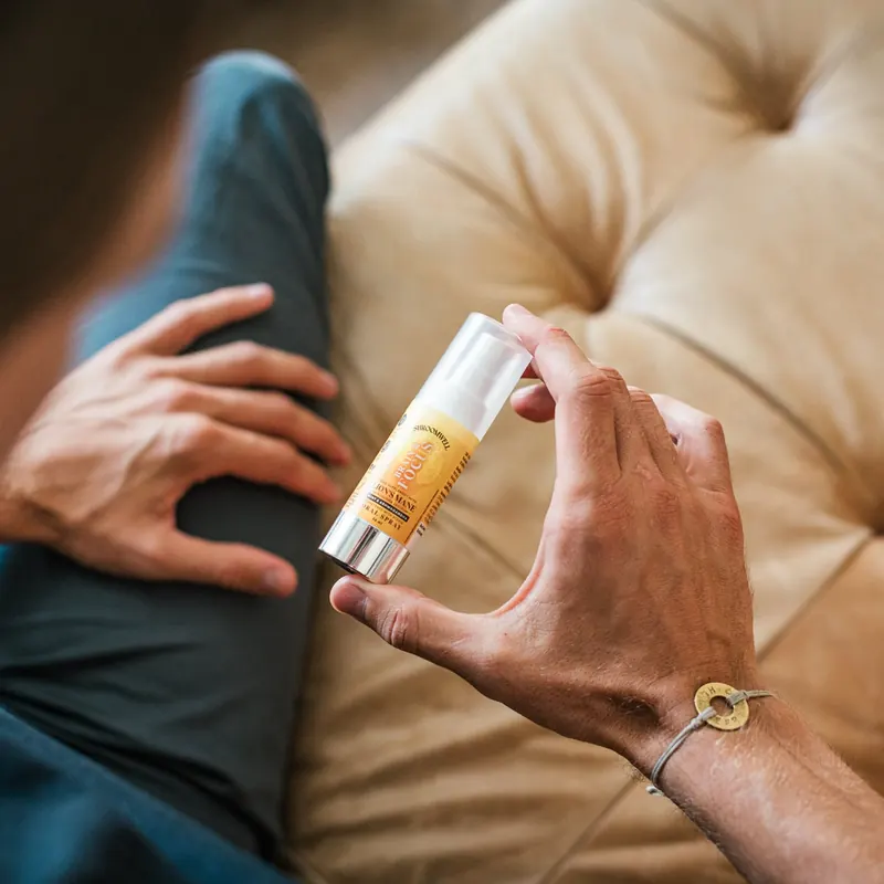 A hand holding the small white Shroomwell spray bottle, from the seller's own photograph